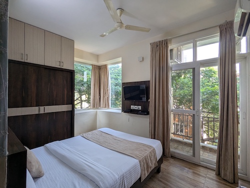 Comfortable king-size bed in a Deluxe Room at AVM Comfort Inn